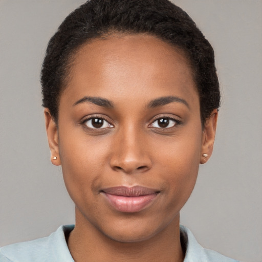 Joyful black young-adult female with short  brown hair and brown eyes