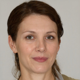 Joyful white adult female with medium  brown hair and grey eyes