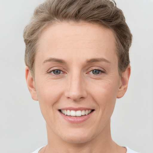 Joyful white young-adult female with short  brown hair and grey eyes