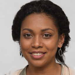 Joyful black young-adult female with long  brown hair and brown eyes