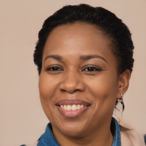 Joyful black adult female with short  black hair and brown eyes