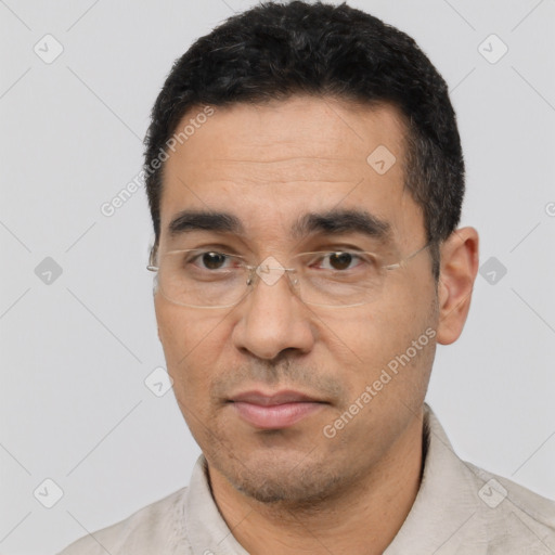 Joyful latino adult male with short  black hair and brown eyes