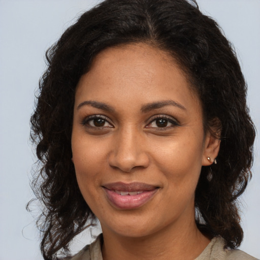 Joyful black young-adult female with long  brown hair and brown eyes