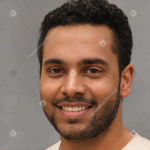 Joyful black young-adult male with short  black hair and brown eyes