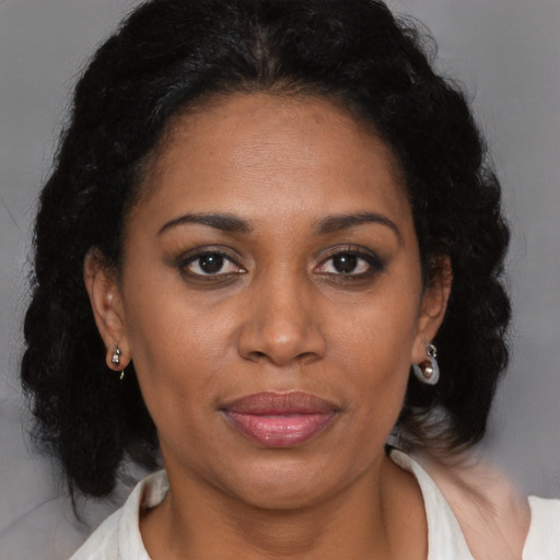 Joyful black adult female with medium  brown hair and brown eyes