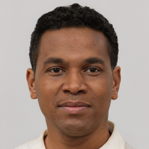 Joyful black young-adult male with short  brown hair and brown eyes