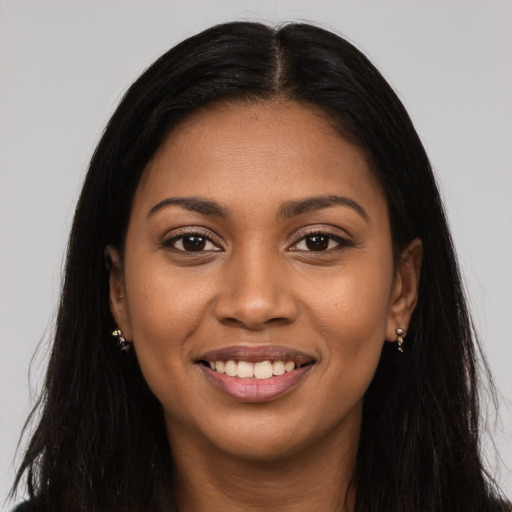 Joyful black young-adult female with long  brown hair and brown eyes