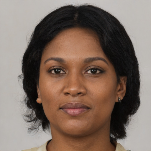 Joyful black young-adult female with medium  black hair and brown eyes
