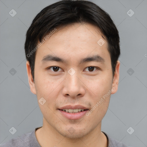 Joyful asian young-adult male with short  brown hair and brown eyes