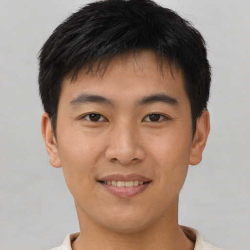 Joyful asian young-adult male with short  brown hair and brown eyes