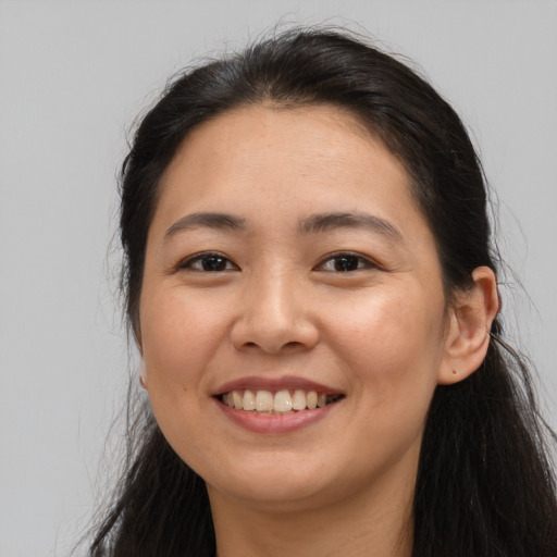 Joyful asian young-adult female with long  brown hair and brown eyes