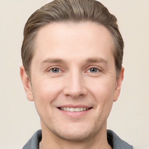 Joyful white adult male with short  brown hair and grey eyes