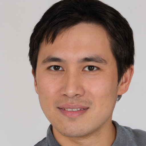 Joyful asian young-adult male with short  brown hair and brown eyes