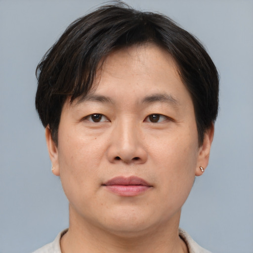Joyful asian adult male with short  brown hair and brown eyes
