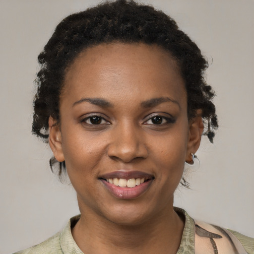 Joyful black young-adult female with short  brown hair and brown eyes