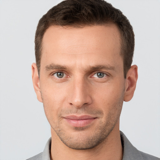 Joyful white young-adult male with short  brown hair and grey eyes