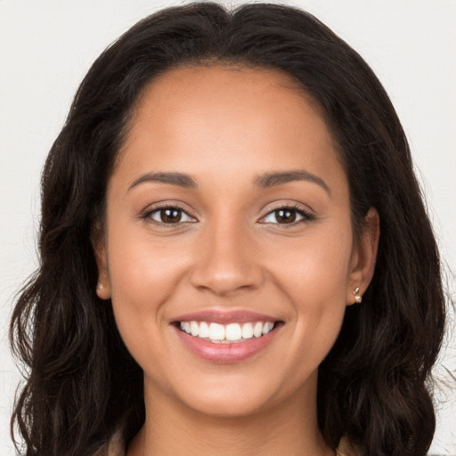 Joyful latino young-adult female with long  brown hair and brown eyes