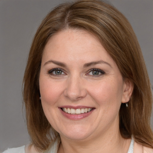 Joyful white adult female with medium  brown hair and brown eyes