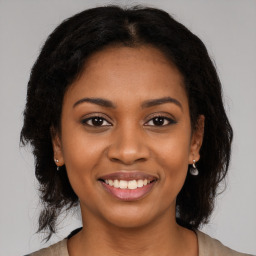 Joyful black young-adult female with long  brown hair and brown eyes