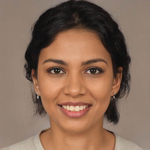 Joyful latino young-adult female with medium  brown hair and brown eyes