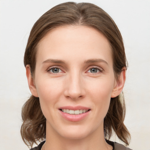 Joyful white young-adult female with medium  brown hair and grey eyes