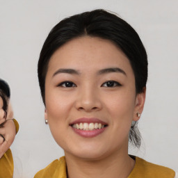 Joyful asian young-adult female with medium  black hair and brown eyes