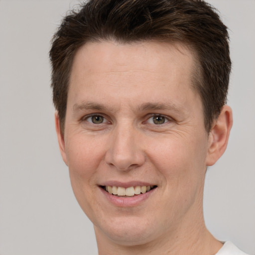 Joyful white adult male with short  brown hair and brown eyes