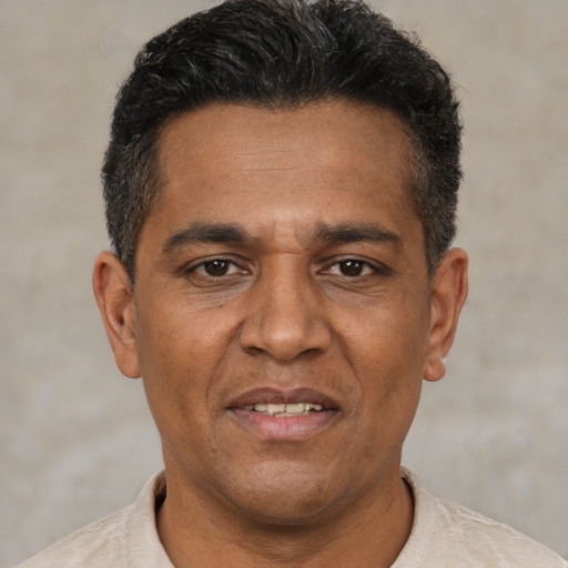 Joyful black adult male with short  black hair and brown eyes