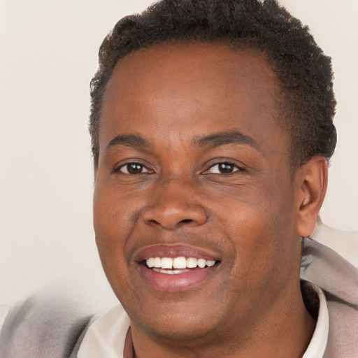 Joyful black young-adult male with short  brown hair and brown eyes