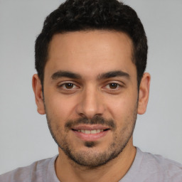 Joyful white young-adult male with short  black hair and brown eyes