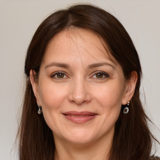 Joyful white adult female with long  brown hair and grey eyes