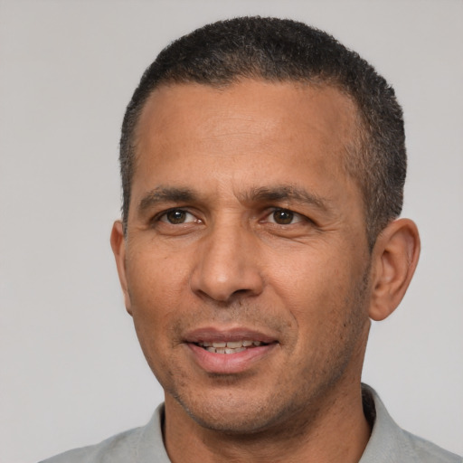 Joyful latino adult male with short  black hair and brown eyes