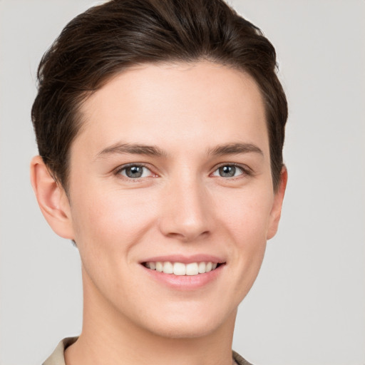 Joyful white young-adult female with short  brown hair and grey eyes