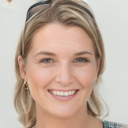 Joyful white young-adult female with medium  brown hair and blue eyes