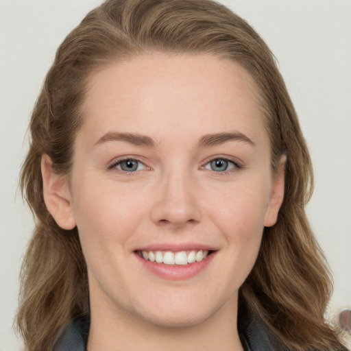 Joyful white young-adult female with long  brown hair and blue eyes