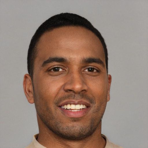Joyful black young-adult male with short  brown hair and brown eyes