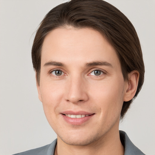 Joyful white young-adult male with short  brown hair and grey eyes