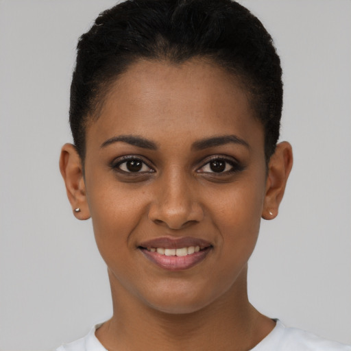 Joyful black young-adult female with short  black hair and brown eyes