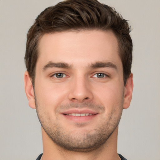 Joyful white young-adult male with short  brown hair and grey eyes