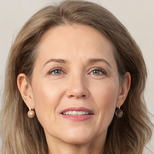 Joyful white adult female with medium  brown hair and grey eyes