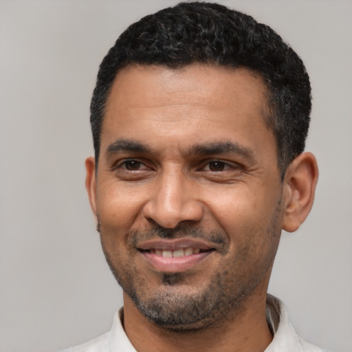 Joyful latino adult male with short  black hair and brown eyes