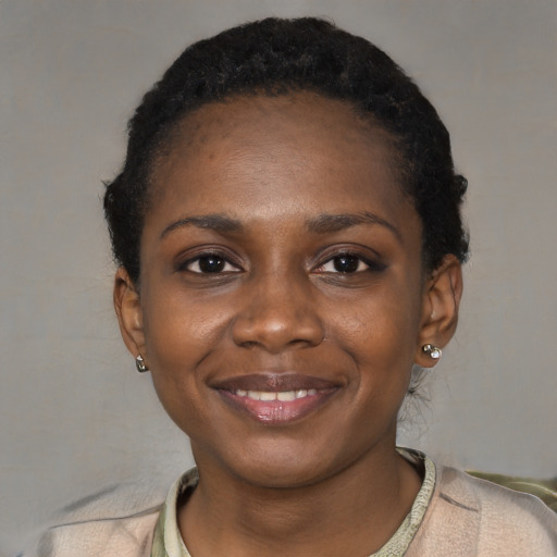 Joyful black young-adult female with short  black hair and brown eyes