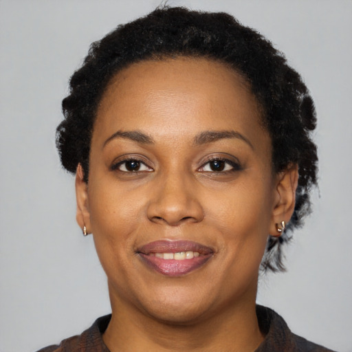Joyful black adult female with short  black hair and brown eyes
