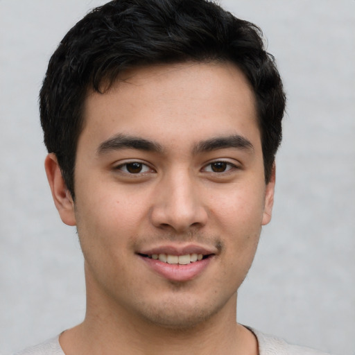 Joyful latino young-adult male with short  brown hair and brown eyes