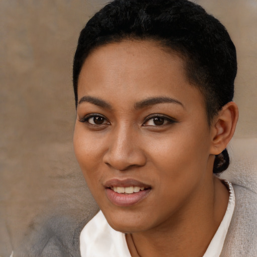 Joyful black young-adult female with short  black hair and brown eyes