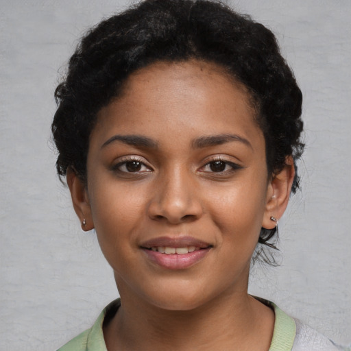 Joyful black young-adult female with short  black hair and brown eyes