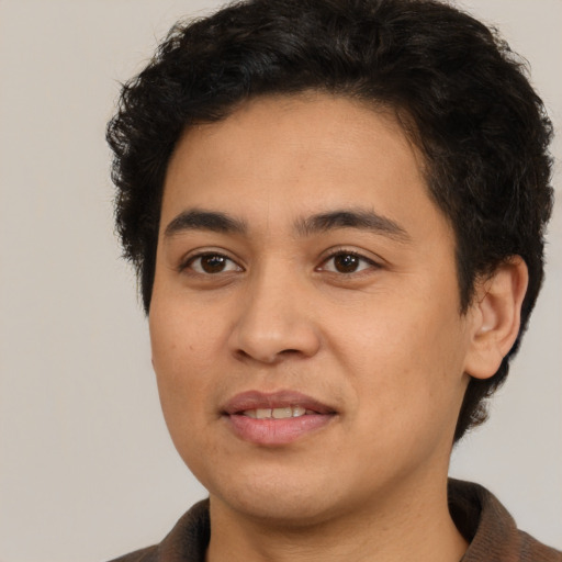 Joyful latino young-adult male with short  brown hair and brown eyes