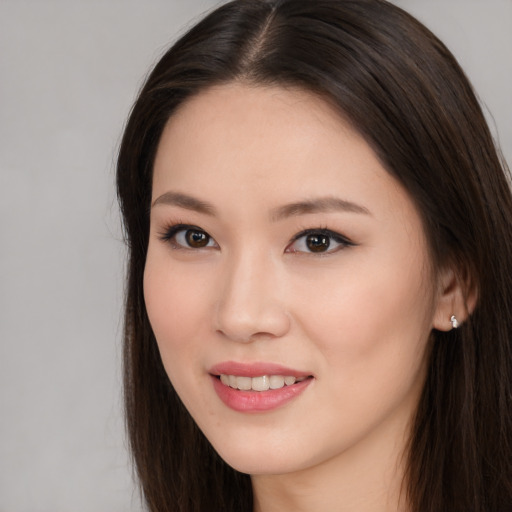 Joyful asian young-adult female with long  brown hair and brown eyes