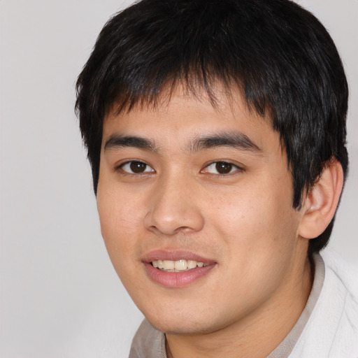Joyful asian young-adult male with short  black hair and brown eyes