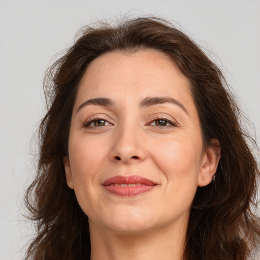 Joyful white adult female with long  brown hair and brown eyes